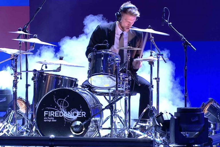 Ein Schlagzeuger bei der Performance am Drum-Kit während einer Bühnenshow der FIREDANCER